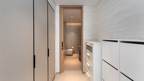 A narrow hallway with a bed, bedside table, and a wardrobe. - Address JBR Elegant 2BR w/ Beach Access (Dubai)