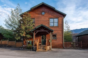 A wooden cabin with a porch, a front door, and a small window. - Eternally Yours (Gatlinburg)