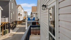 Ein Wohngebiet mit Häusern, einer Holzterrasse und Blick aufs Meer.