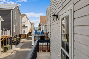 Ein Wohngebiet mit Häusern, einer Holzterrasse und Blick aufs Meer.