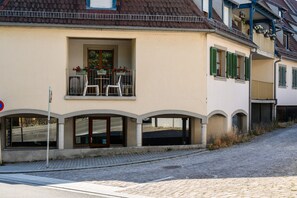 A building with a balcony, a door, and a window.