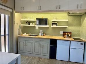 A compact kitchen with white cabinets, a microwave, a coffee maker, and a refrigerator. - Cozy Studio apartment in popular kitesurfing mecca Langebaan with AC (Langebaan)