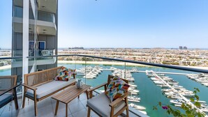 Un balcon avec vue sur un port de plaisance et sur le paysage urbain.