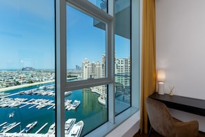 A high-rise room with a large window overlooking a marina and cityscape. - Atlantis View & Private Beach Access | 2BR on Palm (Dubai)