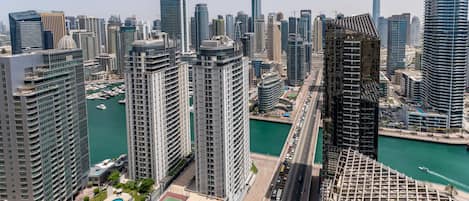A high-rise urban area with modern buildings, a marina, and a pool area.