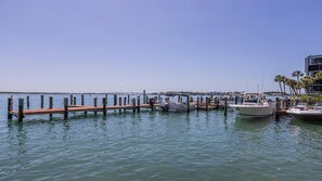 Ein Yachthafen mit vertäuten Booten, eine Holzsteg und ein klarer, blauer Himmel.