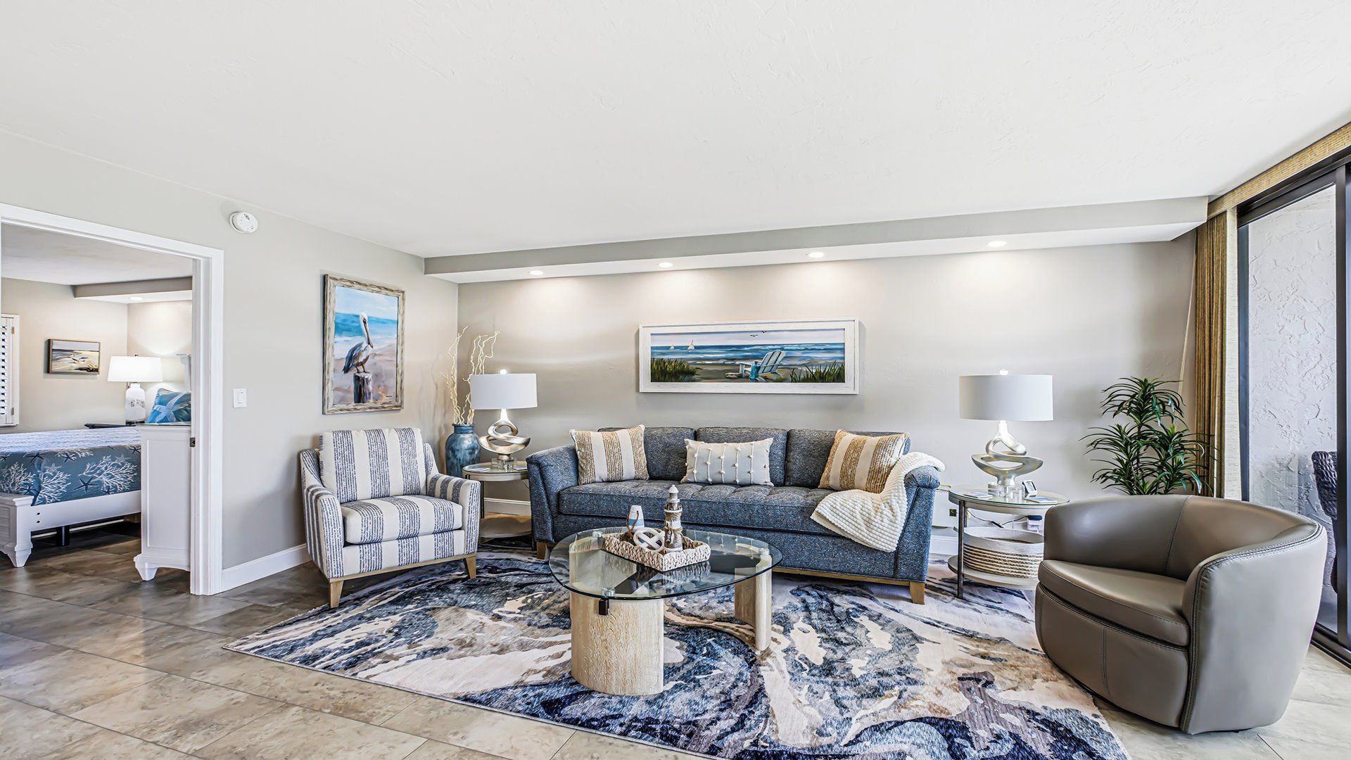 A living room with a sofa, armchair, coffee table, and a rug.