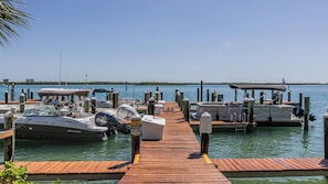 A marina with docked boats, a wooden pier, and a clear view of the water. - Come and experience Paradise at its finest at Riverside Club (Marco Island)