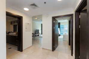 A hallway with a kitchen area, a dining area, and a living space with a view. - Chic Dubai Marina 1BR w/ Pool and Gym (Dubai)
