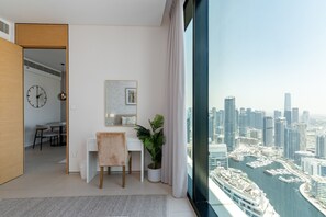 Una habitación moderna con escritorio, silla y vistas a un paisaje urbano.