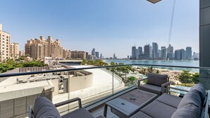 Un balcon avec vue sur la ville, comprenant des immeubles de grande hauteur et une plage.