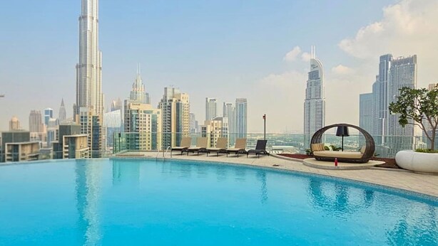 Ein Pool mit Blick auf den Burj Khalifa und andere Gebäude der Skyline von Dubai.