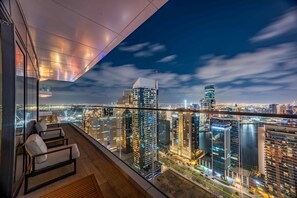 A high-rise building with a view of a cityscape at night. - Urban 3BR Apt | Walk to Dubai Mall & Opera (Dubai)