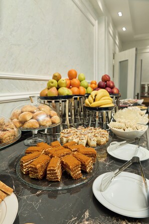 A buffet with various desserts and fruits. - Safia Plaza Hotel (Bukhara)