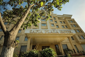 A multi-story building with a sign reading 'SAFIA PLAZA HOTEL' at the entrance. - Safia Plaza Hotel (Bukhara)