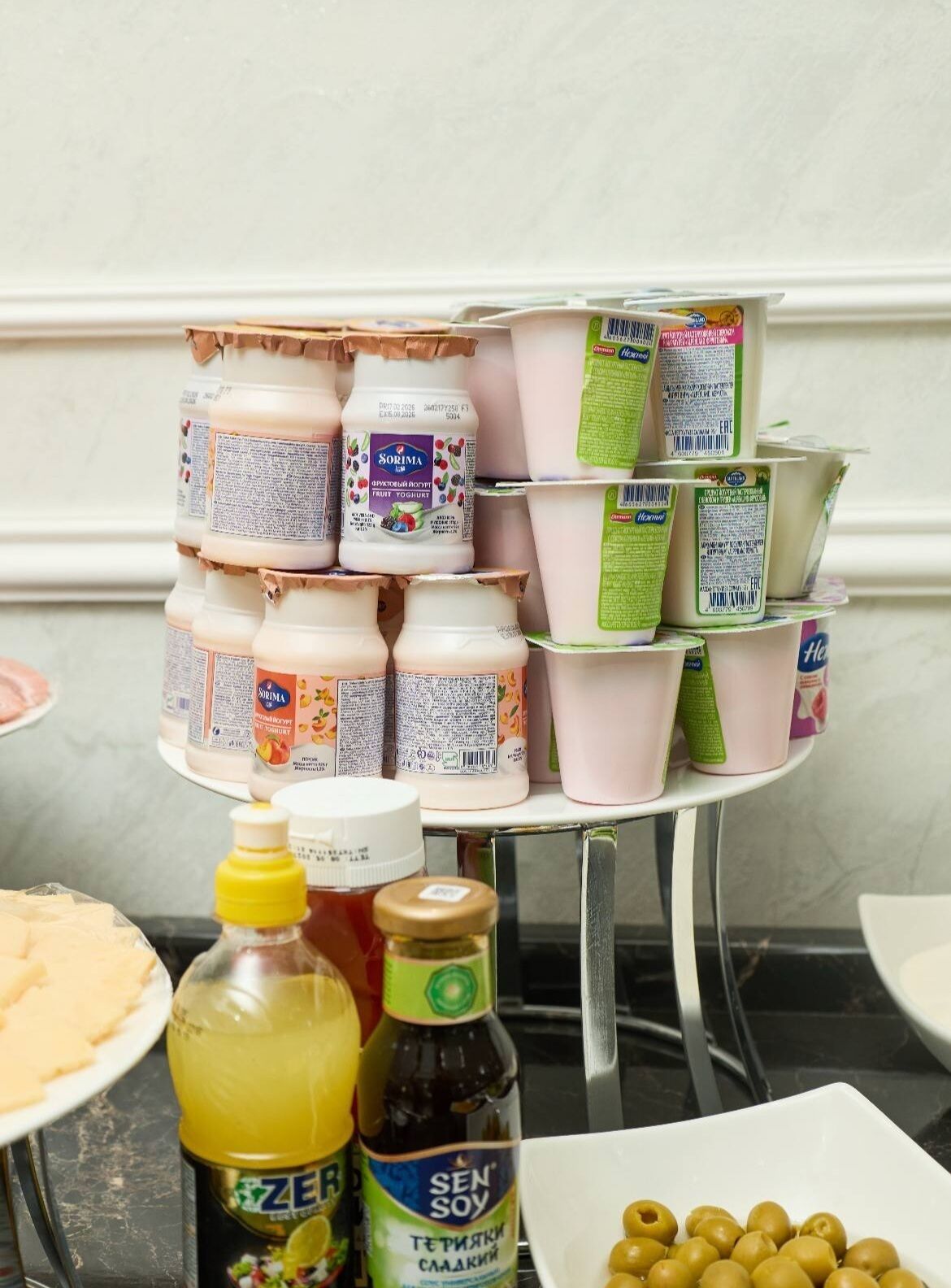 A variety of food items including jars of yogurt, a bottle of lemon juice, and a bottle of soy sauce on a kitchen counter.