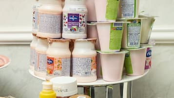 A variety of food items including jars of yogurt, a bottle of lemon juice, and a bottle of soy sauce on a kitchen counter.