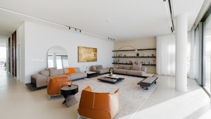 A modern living room with a sofa set, coffee table, and a large mirror. - 4BR Coastal Haven w/  Private Pool | Al Zorah (Ajman)