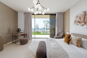 Un dormitorio moderno con una cama grande, un escritorio y vistas al exterior.