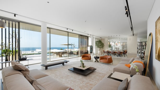 A spacious living room with a large window, a sofa set, a coffee table, and a dining area. - 4BR Coastal Haven w/  Private Pool | Al Zorah (Ajman)