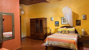 A room with a bed, a wardrobe, a mirror, and a ceiling fan. - Casa Sorpresa mexican charm by the beach (Sayulita)