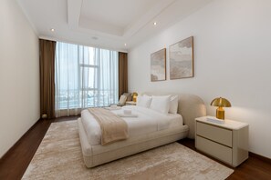 Ein modernes Schlafzimmer mit einem großen Bett, Nachttischen und Kunstwerken an der Wand.