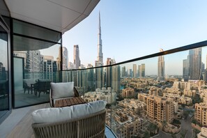 Ein Balkon mit Blick auf eine Stadtansicht, darunter ein markanter Wolkenkratzer.