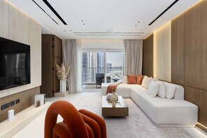 Una sala de estar moderna con un televisor de pantalla plana, un sofá blanco y una mesa de centro.