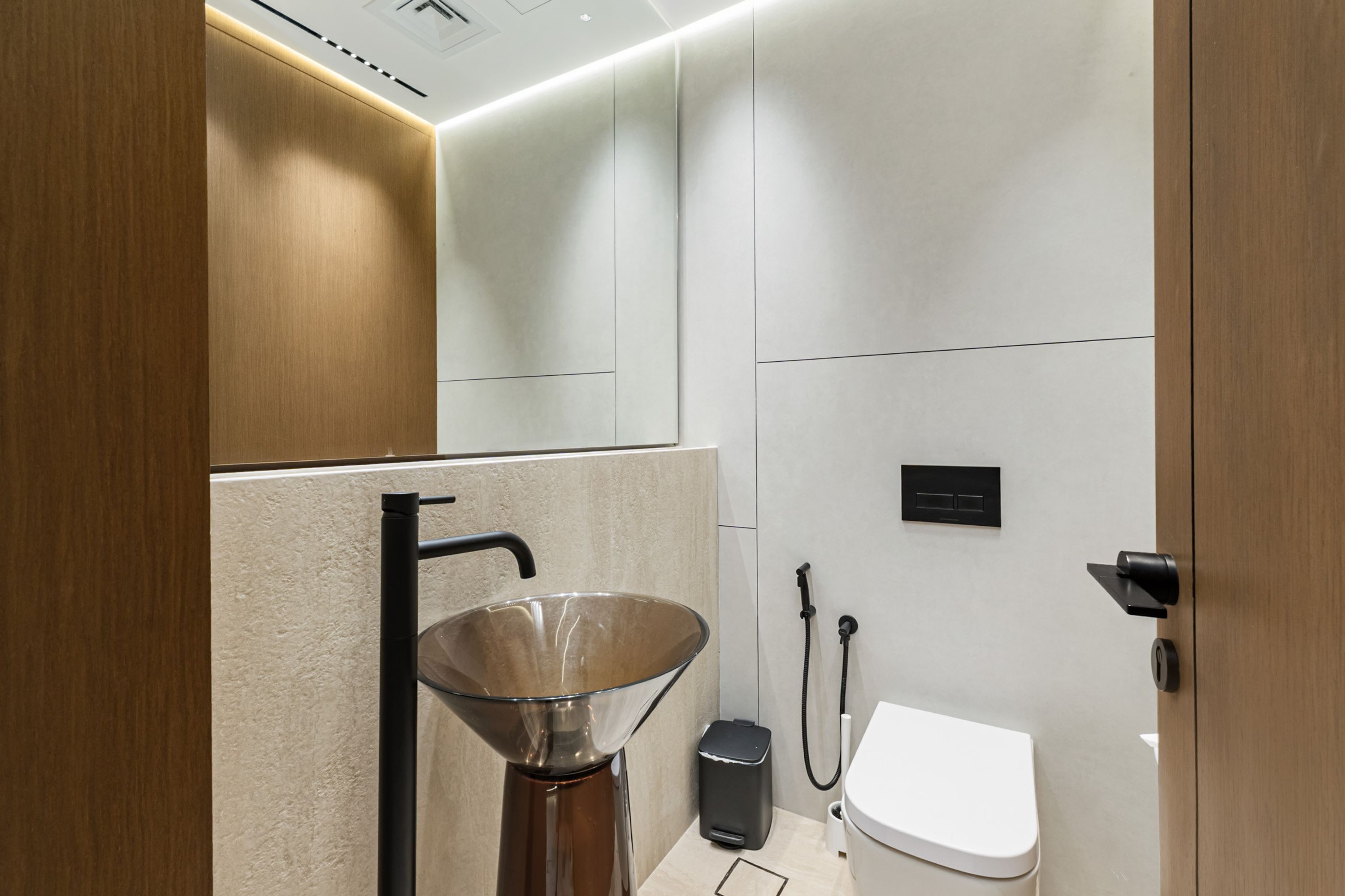 Et moderne badeværelse med vask, toilet og brusebad.