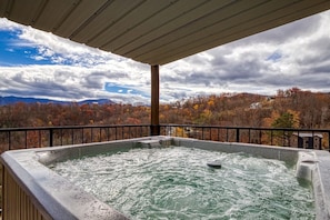 Ein Whirlpool mit Blick auf Herbstbäume und Berge.