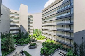 A multi-story residential building with balconies, a central courtyard with greenery, and a modern architectural design. - Newlands Peak 712, The Perfect Stop (Cape Town)