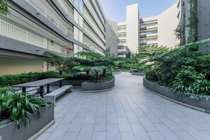 A modern building with multiple floors, outdoor seating areas, and lush greenery. - Newlands Peak 712, The Perfect Stop (Cape Town)
