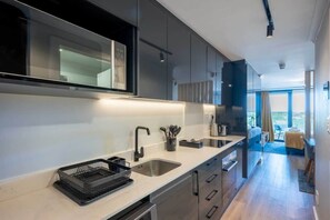 A modern kitchen with a large window, a built-in oven, and a sink.