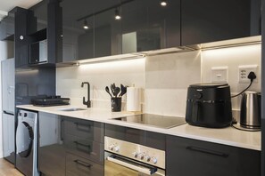 A modern kitchen with a dishwasher, oven, and a coffee maker. - Newlands Peak 712, The Perfect Stop (Cape Town)