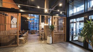 Ein modernes Interieur mit einer Sitzecke, großen Fenstern und einer Zimmerpflanze.