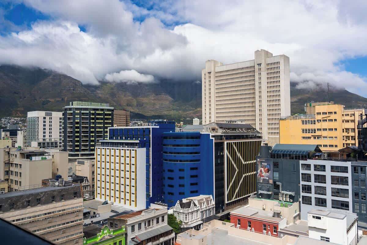 A cityscape with various buildings, including a prominent white skyscraper and a blue building with a unique facade.