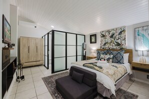 A bedroom with a bed, a sofa, a wardrobe, and a large window. - Bishopscourt- Secret Garden hideaway (Cape Town)