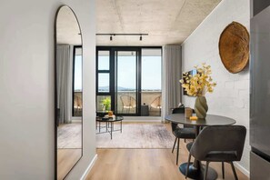 Ein modernes Interieur mit Essbereich, einem großen Spiegel und Blick ins Freie.