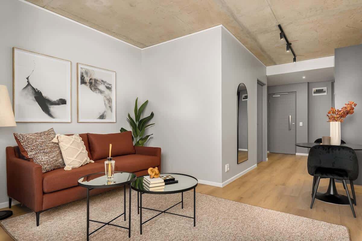 Een moderne woonkamer met een bank, salontafel en kunst aan de muur.