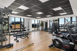 Ein Fitnessstudio mit Gewichten, Laufbändern und Kurzhanteln.