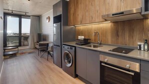 A modern kitchen with a built-in washing machine, a stainless steel oven, and a large window overlooking a cityscape. - Riverlands- Sunbird Golden Nectar (Cape Town)
