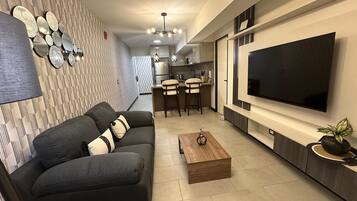 Appartamento Business, 1 letto queen, vista città | Area soggiorno | Smart TV 55 pollici con canali via cavo