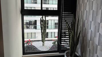 Une pièce dotée d’une grande fenêtre, d’une plante en pot et d’un mur orné d’un motif.