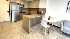 Eine moderne Küche mit Einbau-Mikrowelle, Kaffeemaschine und Spüle.