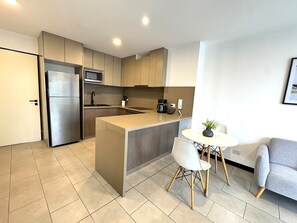 A modern kitchen with a built-in microwave, a coffee maker, and a sink. - Aparts4Days 1 Bedroom Apartment 548 (San Isidro)