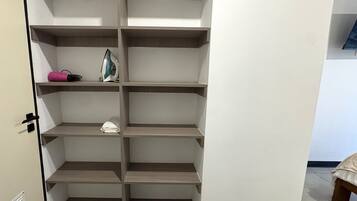 A walk-in closet with multiple shelves and a door.