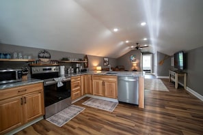 A spacious kitchen with wooden cabinets, stainless steel appliances, and a central island.