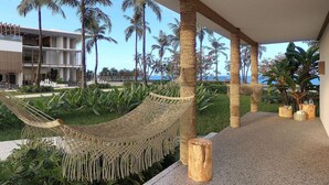 A hammock, palm trees, and a modern building with a balcony. - Jeriquiá Lagoa Resort - Gav Resorts (Cruz)