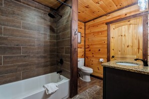 Een badkamer met een bad, toilet en wastafel.