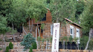 A stone building with a sign for Beel Hills, surrounded by trees. - Beel Hills - SOLARA (Mar Mikhael Bnabil)